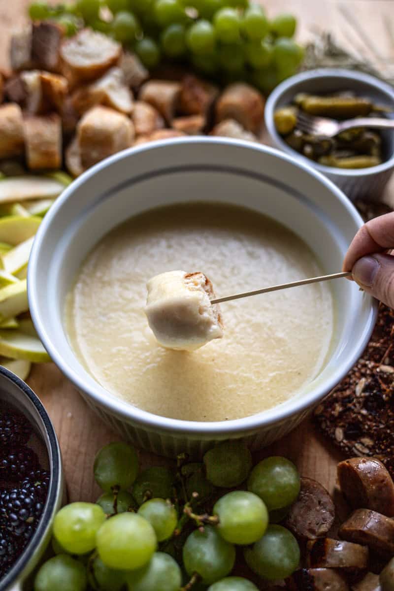 bread being dipped into cheese fondue