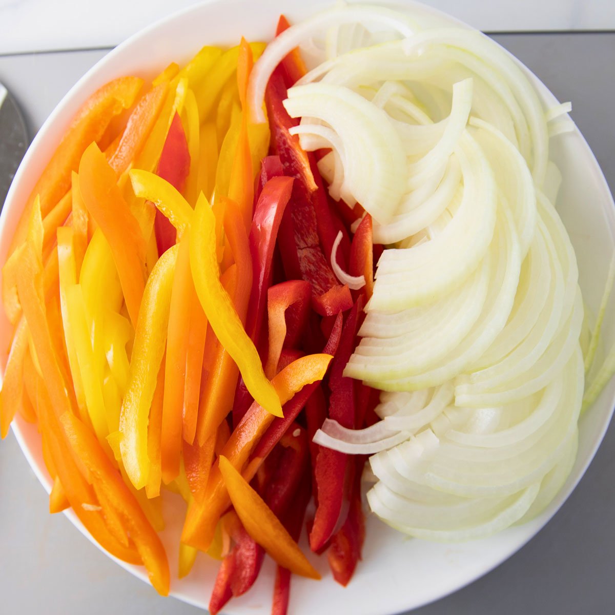 overhead of bowl of sliced peppers and onion to make fajita veggies