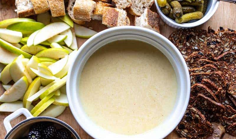 cheese fondue on board with toppings for dipping