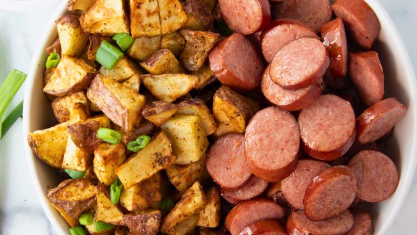 overhead of bowl of air fryer kielbasa and potatoes with a side of ketchup