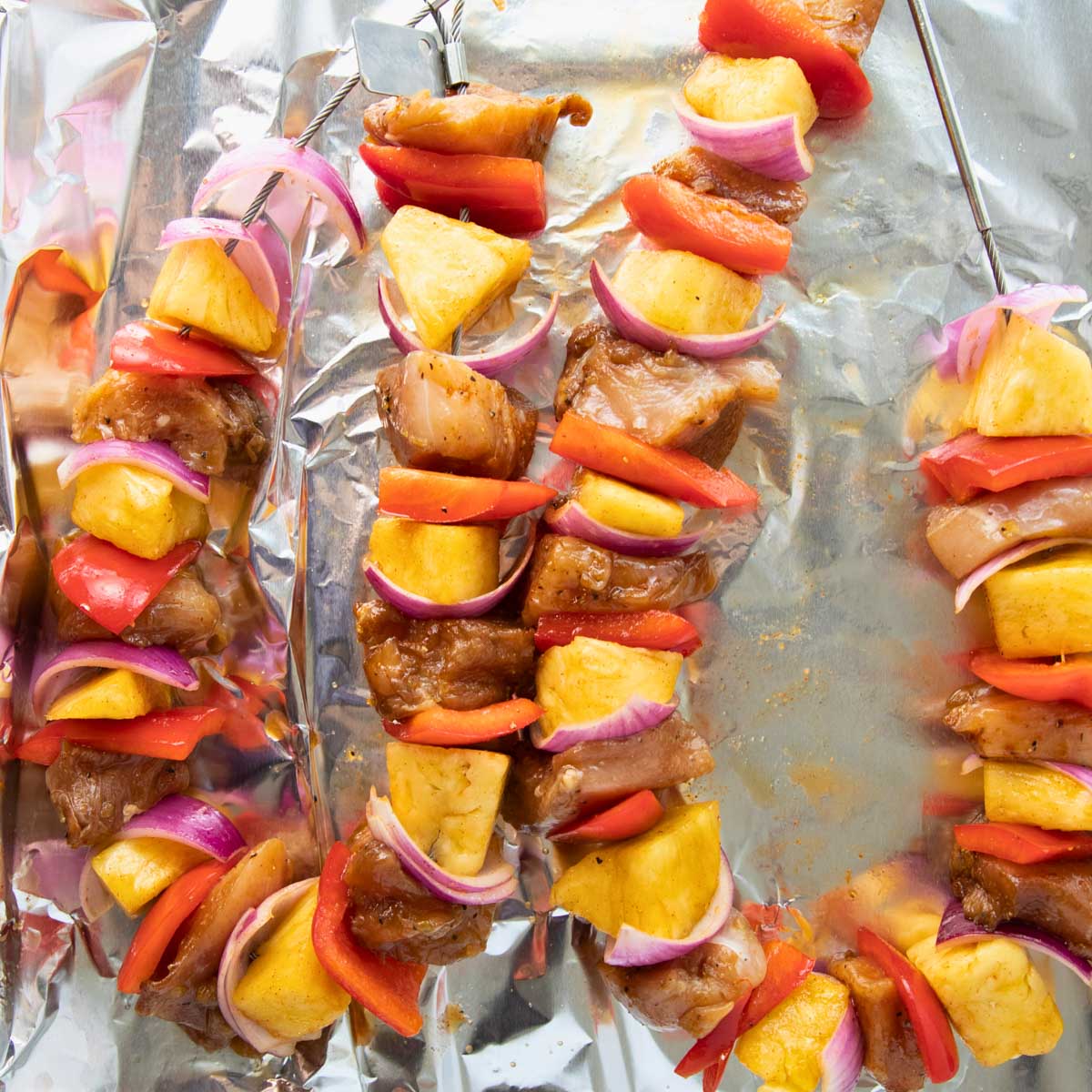 kabobs threaded with chicken, red peppers, onions and pineapple